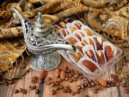 Eastern sweets with nuts, candy, dates in box background, closeup
