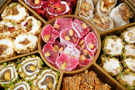 Eastern sweets with nuts, candy, dates in box background, closeupの写真素材