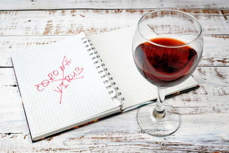 mental health in during coronavirus pandemic concept, word coronavirus in notebook, psychological problems covid-19 concept, woman tearing paper in tantrum and drink wine, alcoholism problemの写真素材