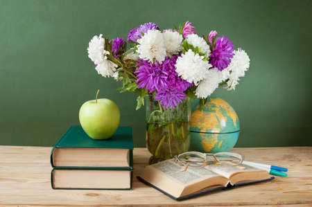 World Teacher's day concept. Flowers bunch, map, globe and books pile