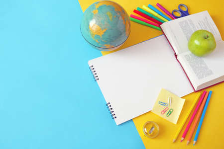 Back to school, books pile, pencils, apple, globe and apple over chalkboard background