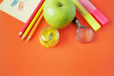 Back to school, books pile, pencils, apple, globe and apple over chalkboard background
