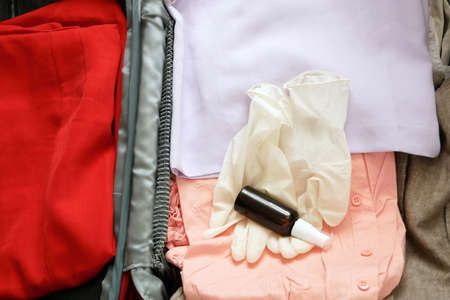 travel suitcase, sun hat, passports and medical mask on wooden background, flat lay, problems in the...