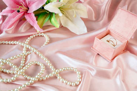 wedding rings in a gift box with flowers and pearl necklace, wedding backgroundの写真素材