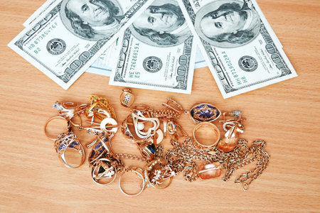jewelry scrap of gold and silver and money, pawnshop concept jeweler looking at jewelry through magnifying glass, jewerly inspect and verifyの写真素材