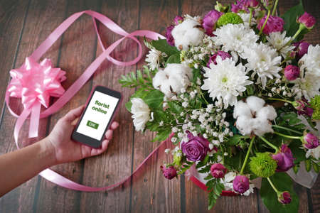 Business owner in flower shop, florist online with big flowers bunch, workplace florist, top view