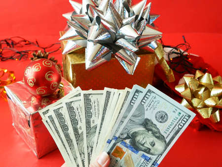 big gift box with ribbon bow and stack of money, merry chirtmas and happy new year concept