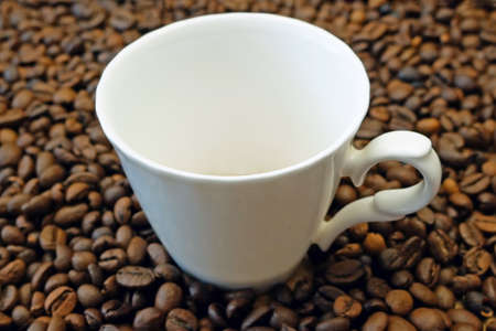 empty coffee cup with coffee beans on wooden background, closeup