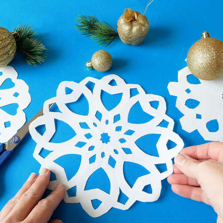 snowflakes paper crafts, handmade new year decoration on blue background, xmas moodの写真素材