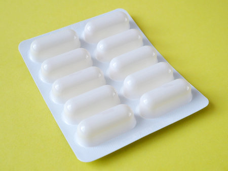 white pills in blister on yellow backgroundの写真素材