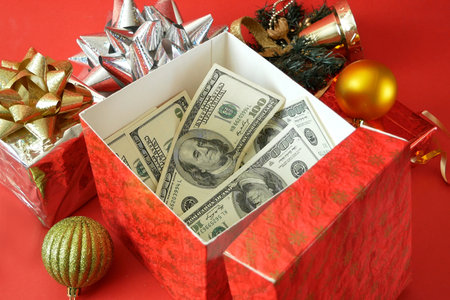 big gift box with ribbon bow and stack of money, merry chirtmas and happy new year concept, closeupの写真素材