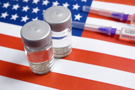 american flag, syringes with coronavirus vaccine, purchase and production vaccine concept, closeupの写真素材