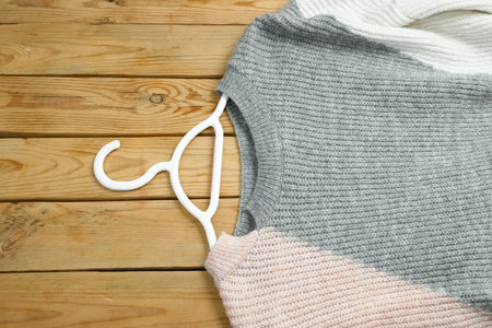 sweaters and skirt on hangers on wooden background with red price tag, winter sales conceptの写真素材