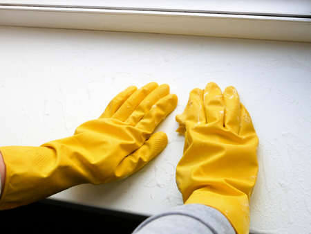 Woman gloves windowsill washing. Window cleaning servicesの写真素材