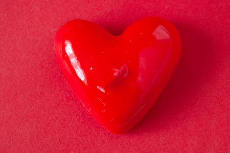 red candle shapes heart on red background, valentine's day conceptual greeting card with copy spaceの写真素材