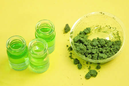 Cannabis oil with marijuana plant in bottles plant on yellow background. Cannabis cosmetics concept