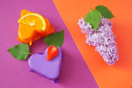 Orange and strawberry cheesecakes and lilac flowers, blank for menu of cafe or restaurant, top viewの写真素材