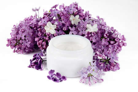 cream cosmetic and extract in lilac cosmetic with flowers on white background, closeupの写真素材