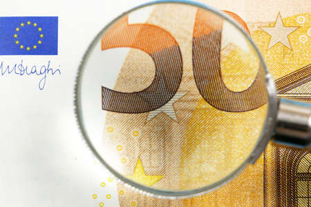 magnifying glass inspect paper money, finances and exchange, closeup