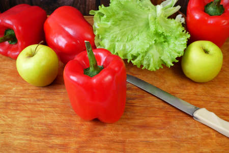 sweet red pepper, apple and lettuce on wooden background, top view, closeupの写真素材