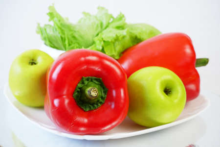 sweet red pepper, apple and lettuce in white plate on white, closeupの写真素材
