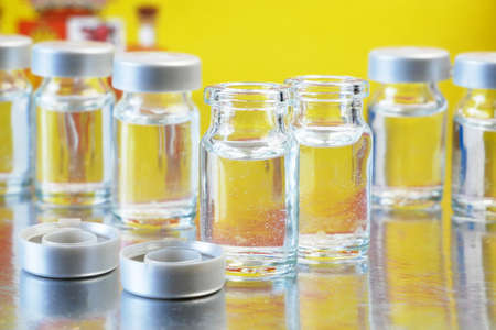 bottles and syringes with vaccine against covid-19 on Spain flag background, vaccination against coronavirus in Spain started concept, closeupの写真素材