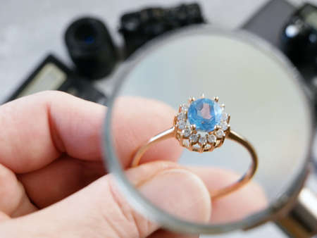 jeweler looking at ring with blue stone, jewerly inspect and verify, pawnshop concept, jewerly shop,...
