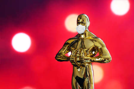 Hollywood Golden Oscar Academy award statue in medical mask. Success and victory concept. Oscar ceremony in coronavirus timeのeditorial素材