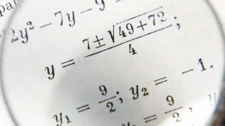 magnifying glass increases the mathematical formulas on paper book. Business concept. School education and graduation concept. Closeupの写真素材