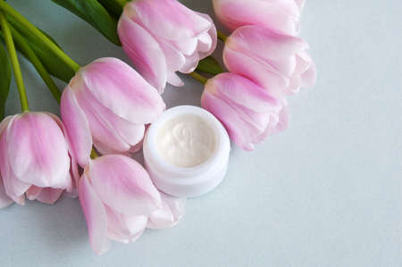 Cream cosmetic in bottle, fresh pink tulips flowers, natural cosmetic concept, closeupの写真素材