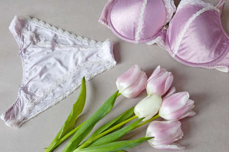 beautiful underpants and bra with colorful lace and tulips bunch on gray background, underwear sales concept, closeupの写真素材
