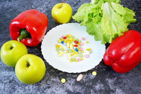 healthy food (vegetables, fruits) vs pills concept, closeup