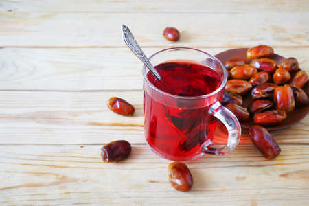 Eastern sweets with nuts, candy, metal vase, tea, dates on wooden background