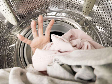 Unknown woman puts the laundry in the washing machine, inside the washing machine, closeupの写真素材