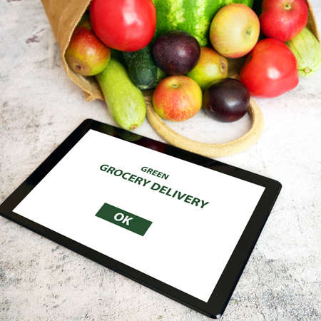 Organic Vegetables and fruits in cotton bag and tablet pc, online market, green grocery delivery at...
