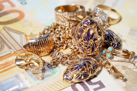 golden jewelry and stack of money, pawnshop concept, closeupの写真素材