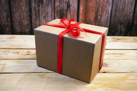 Gift parcel box with ribbon red bow, brown carton parcel, surprise, closeup