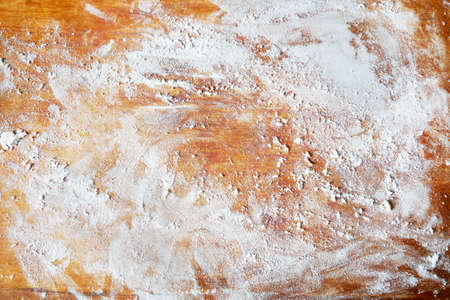 white flour on rustic wooden table, top view, closeup