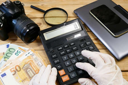 laptop, calculator, digital camera and money, store selling photographic equipment, pawnshop concept, closeupの写真素材