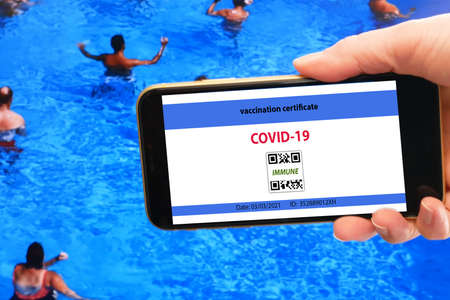 Vaccination passport on a mobile phone allowing travel in hand. Community or Health passport, closeupの写真素材