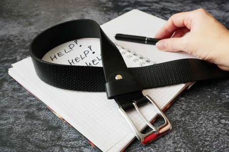 notebook with psychological trauma inscription and dark leather male belt as ptsd symbol on black...
