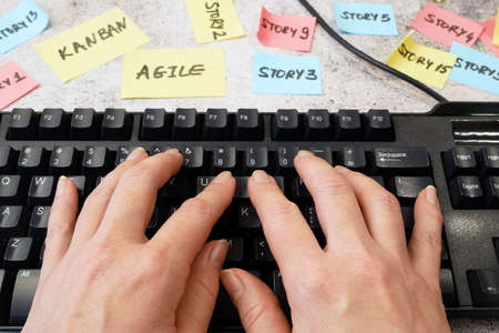 hand working in keyboard, software scrum agile board with paper task, agile software development...