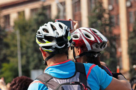 man and woman in cyclist helmets on city background, Happy Couple Cycling In The City, outdoorsの写真素材