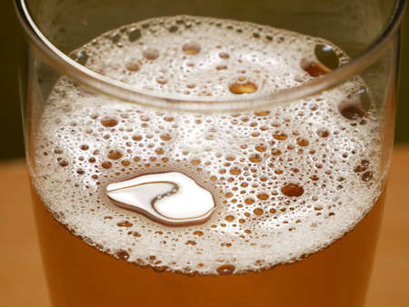 Beer Glass On A Wooden Table. Craft Beer festival. Beer with foam in a pub. Alcohol drink, closeup