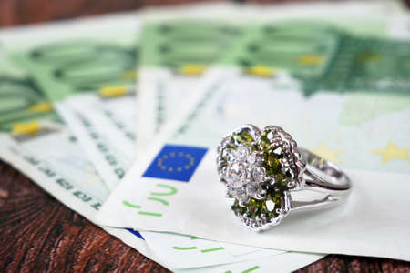 money and jewelry, pawn shop and buy and sell, rings and money euro on wooden background, closeupの写真素材