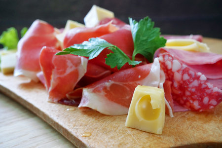 Cold Smoked Meat Plate, antipasto set platter wooden plate. Cold smoked meat plate with sliced ham, prosciutto, bacon and cheese. Copy space. Top view, closeupの写真素材