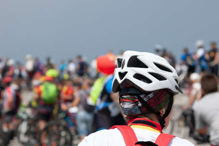 Cyclist in helmet on during cycle ride in city in summer day, closeup
