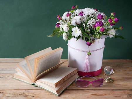 stack of books and a bouquet of flowers on artistic background. Teacher's Day. Still life