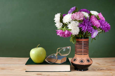 stack of books and a bouquet of flowers on artistic background. Teacher's Day.の写真素材
