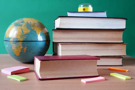 Back to school, books pile, pencils, globe over chalkboard background, closeupの写真素材